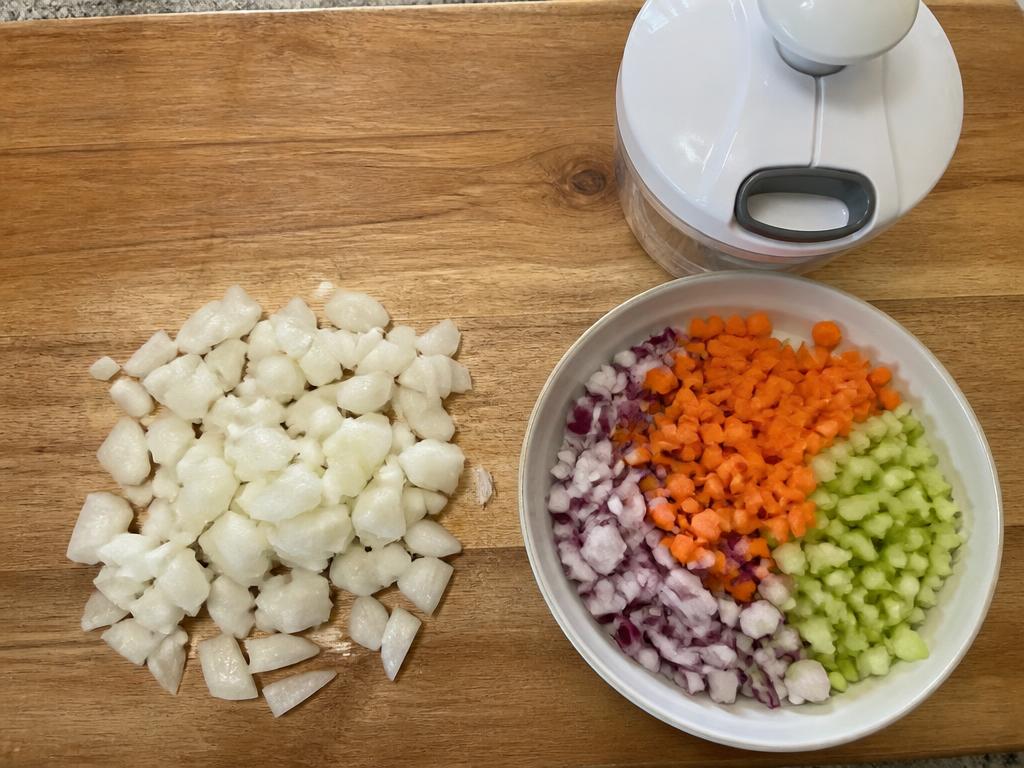 Comparación entre cebolla picada a cuchillo de forma irregular y verduras picadas de forma uniforme junto al picador